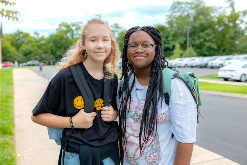 Two students smile